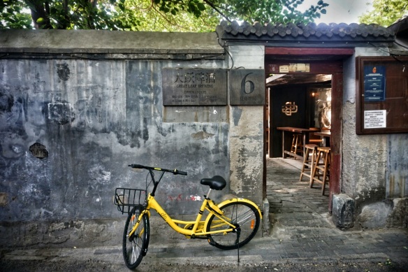 Entrance to Great Leap Brewing's original Doujiao Hutong location with an ofo share bike parked in front.